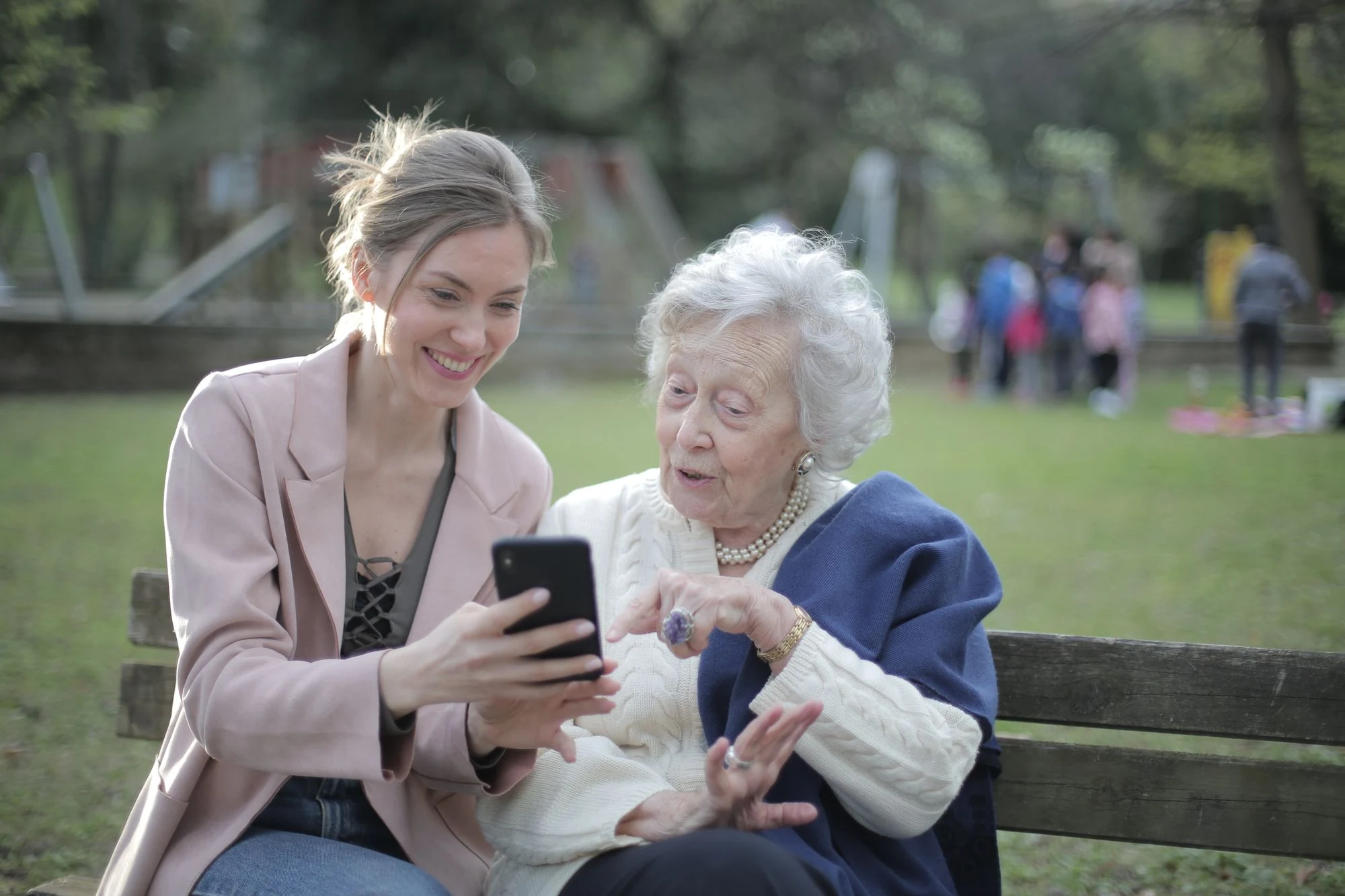 An older woman and a younger woman sharing a moment outdoors.